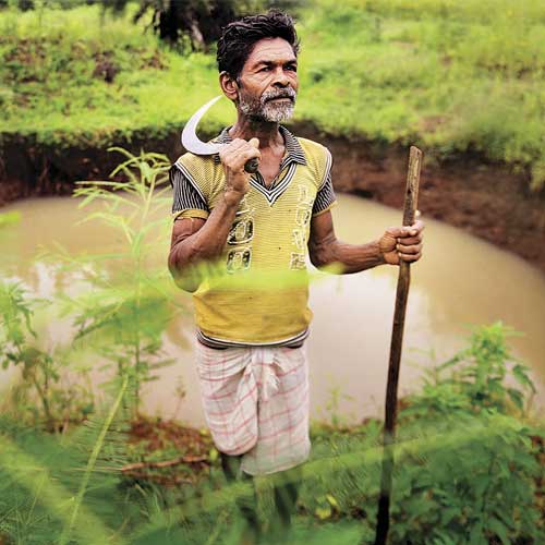 Sonji Sravan Tumdaa near the waterlogged ditch being passed off as a completed well at Kasa Budruk village in Vikramgad.