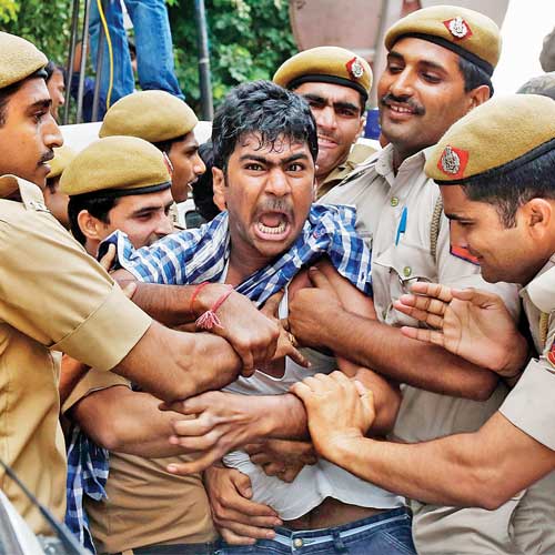 Police detain a supporter of Chandrababu Naidu in New Delhi on Friday.