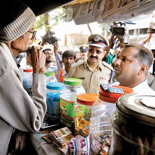 Health minister UT Khader and city police commissioner Raghavendra Auradkar educating a petty shop owner about rules that prohibit advertising of cigarette brands.