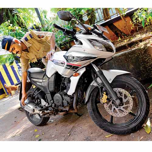 A policeman attached with Dongri police station checks the bike which was involved in the fatal accident on the Eastern Freeway but suffered no damage, on Sunday.
