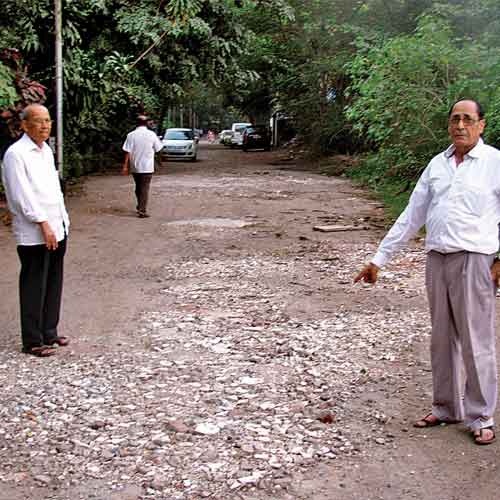 Residents of Chheda Nagar, Chembur, inspect the 400-metre long damaged road in their area on Friday.