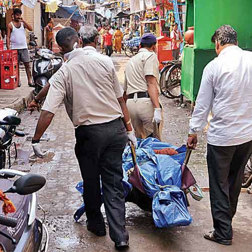 Body of a man, who was found dead in his Oshiwara flat, is being taken away by policemen on Wednesday.