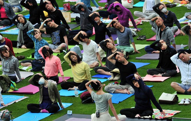 Japanese yoga students participate in an outdoor yoga class at a park in Tokyo on May 5, 2014. Some 450 participants took part in the event "Midpark yoga" during Japan's week-long 'Golden Week' holiday. AFP PHOTO / Yoshikazu TSUNO Japanese yoga students participate in an outdoor yoga class at a park in Tokyo on May 5, 2014. Some 450 participants took part in the event "Midpark yoga" during Japan's week-long 'Golden Week' holiday. AFP PHOTO / Yoshikazu TSUNO