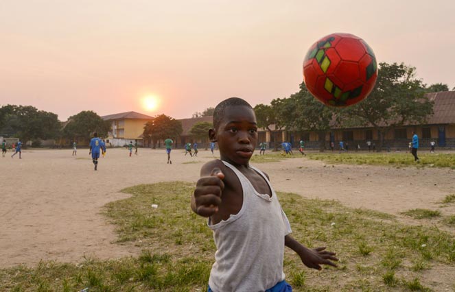 A child juggles with a ball in the Gombe neighbourhood in the city of Kinshasa on June 12, 2014. AFP PHOTO / Junior D. Kannah A child juggles with a ball in the Gombe neighbourhood in the city of Kinshasa on June 12, 2014. AFP PHOTO / Junior D. Kannah