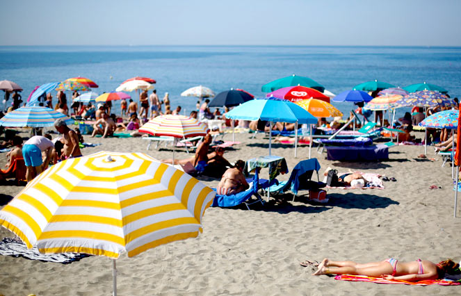 People sunbathe at Ostia beach, west of Rome, Italy, on Sunday, June 8, 2014. Italy's beaches are a family affair – and that's a problem for the euro zone's third-largest economy. Most of the beaches along Italy's 7,500 kilometres of sun-kissed coast have for decades been managed by small businesses operating concessions that are passed on from generation to generation. Though licences are state-owned, they rarely come up for public bids, allowing Italy's balneari – or beach managers – to keep a tight grip on amenities ranging from single-shack parasol rentals to up-market bars and restaurants. Image: Reuters/Max Rossi sunbathing-rome