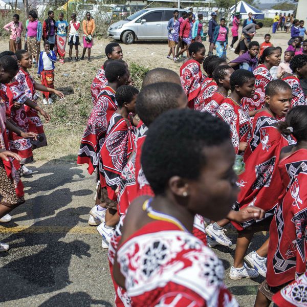 Swazi girls sing and dance as they walk to Sawzi king's royal residence for the annual reed dance. 