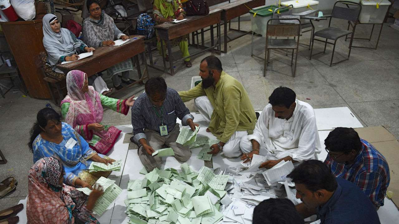 Pakistani election officials count ballots papers after polls closed at a polling station in Karachi on July 25 AFP