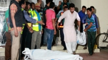 The bodies of two gay rights activists who were hacked to death are brought down from an apartment in Dhaka