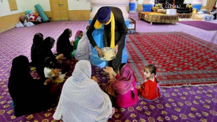 In this Sunday, April 24, 2016 photo, Pakistani Sikh receive parshad or holy food distributed by a man, at the 300-year-old gurd