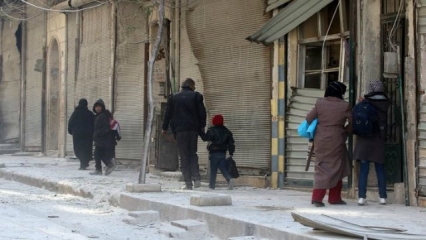 Syrians carry their belongings as they flee clashes between government forces and rebels in Tariq al-Bab and al-Sakhour neighbor